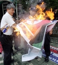 South Korean protesters burn defaced a North Korean flag and portrait of North Korean leader Kim Jong Il during a rally against North Korea's missile launching near the presidential house in Seoul, Wednesday, July 5, 2006.  North Korea test-launched six missiles including a long-range Taepodong in an early morning barrage Wednesday, violating its own seven-year moratorium on such launches and defying stern international warnings of retaliation.  (AP Photo/Ahn Young-joon)